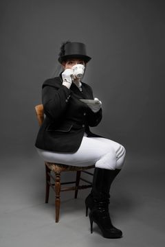 Mistress Elaina, in Her equestrian gear, drinking tea