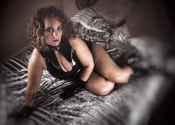 Mistress Elaina waiting on a bed